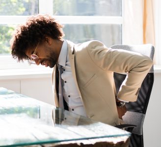 back pain sitting on an office chair. An ergonomic chair can help with sciatica and pinched nerve pain